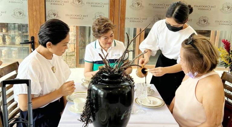 Raquel (left) and guests look on the iconic sikwate or cacao drink being poured into the cup. | CebuFinest